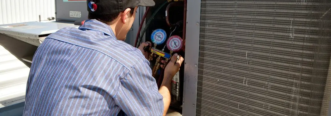 HVAC technician servicing a condenser unit in Bay Point